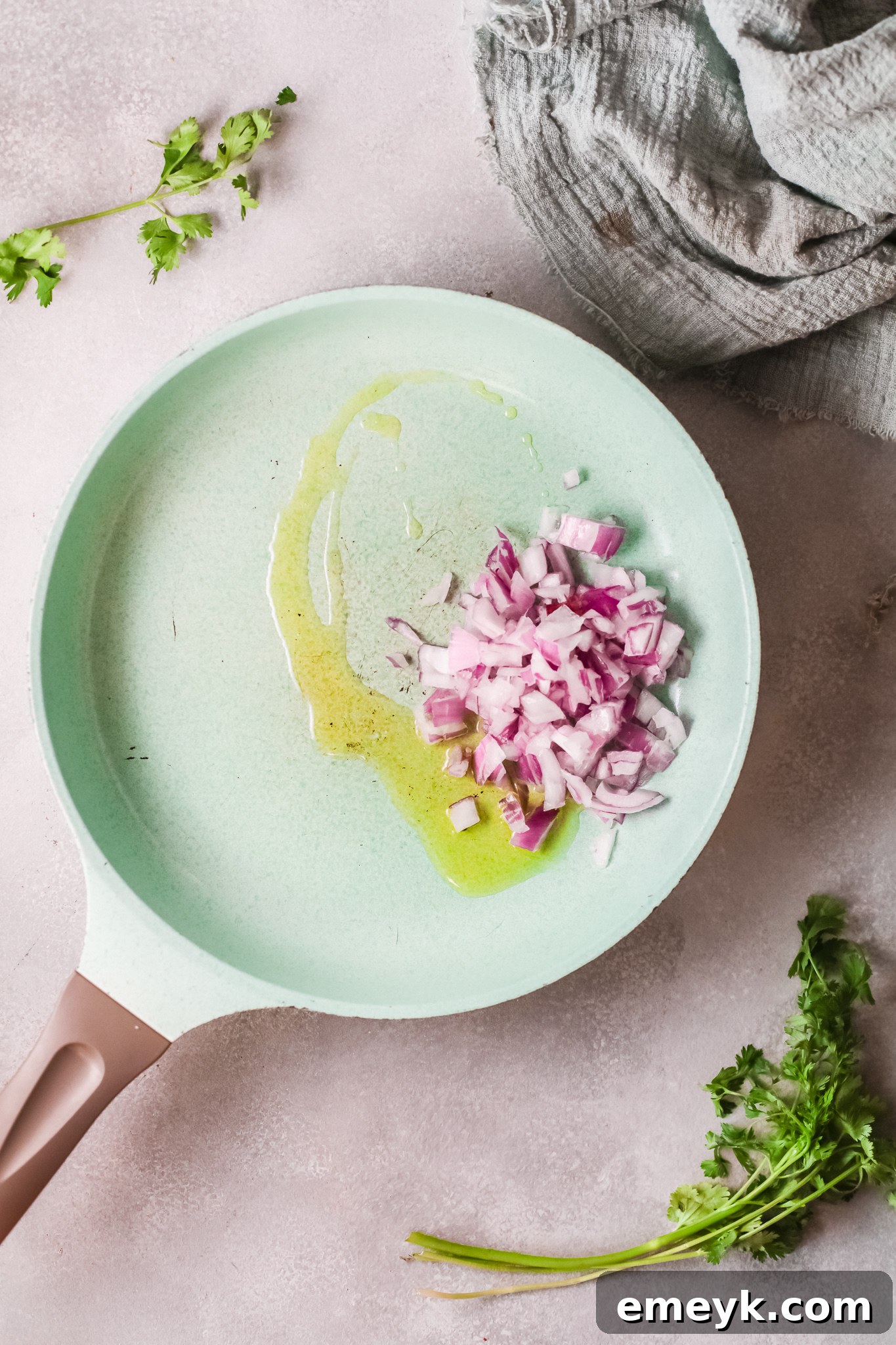Diced red onions and minced garlic sautéing in olive oil in a large pan.