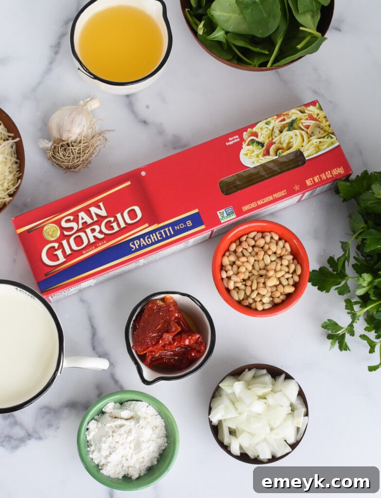 A visual spread of fresh ingredients for Creamy Sun-Dried Tomato Pasta including pasta, sun-dried tomatoes, spinach, and cheese.