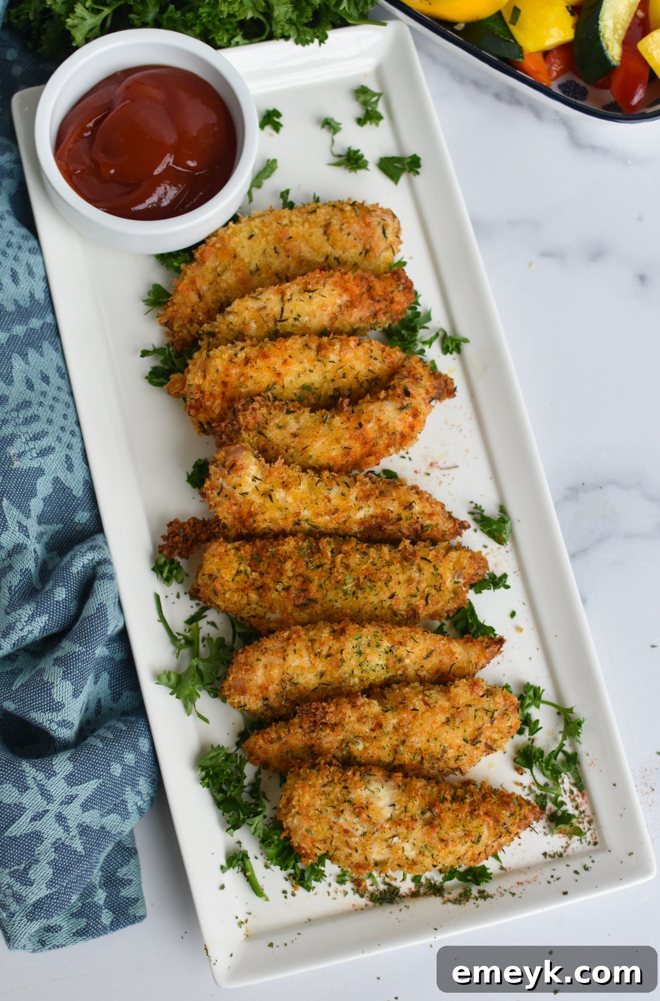 Golden Crispy Air Fryer Chicken Tenders 3 Air Fryer Chicken Tenders on a white long platter.