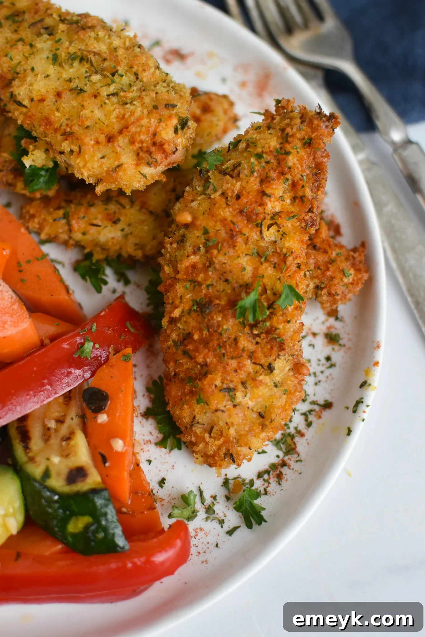 Golden Crispy Air Fryer Chicken Tenders 7 Air Fryer Chicken Tenders with vegetables on a plate.