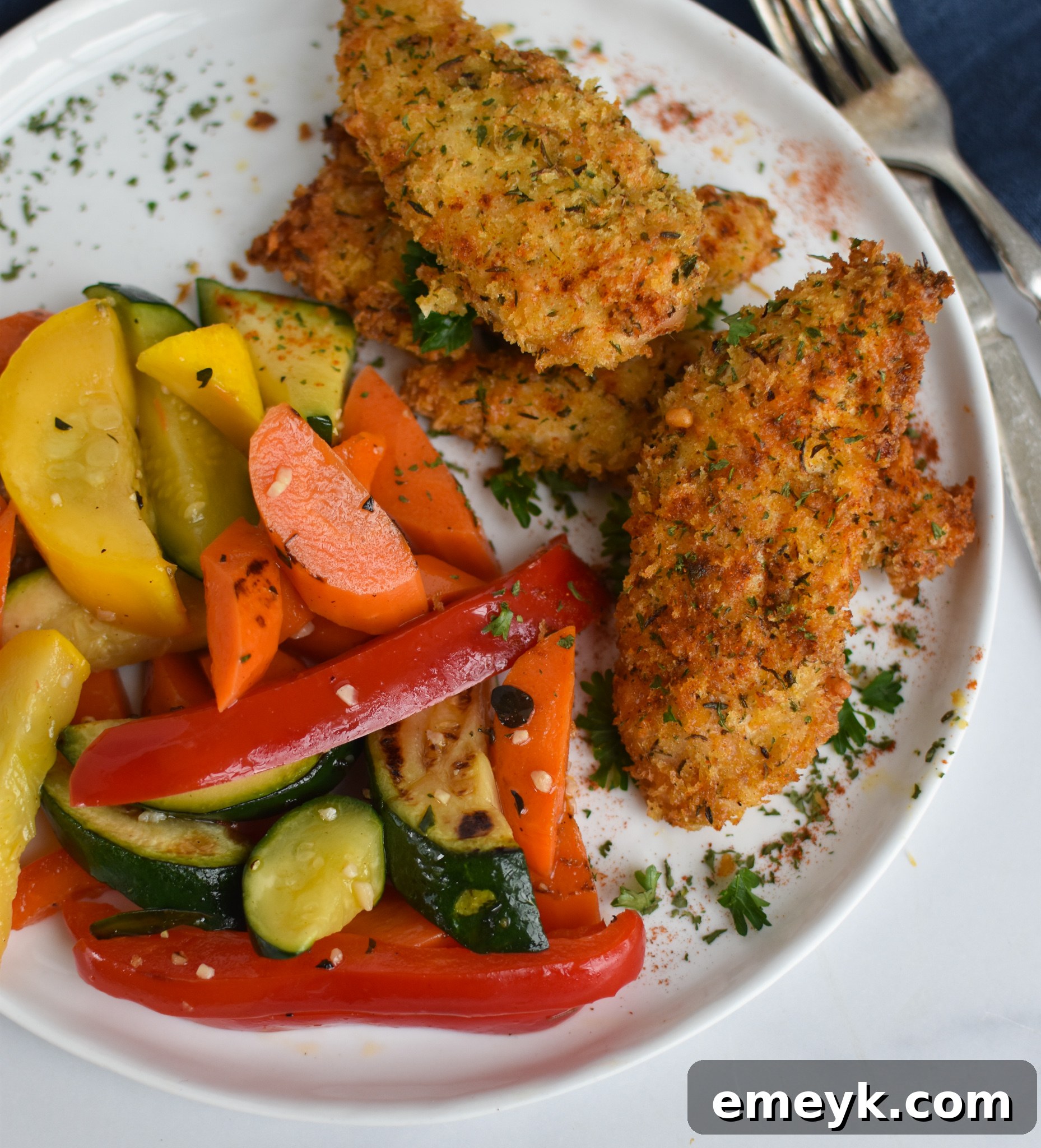 Golden Crispy Air Fryer Chicken Tenders 10 Air Fryer Chicken Tenders with parsley as a garnish.