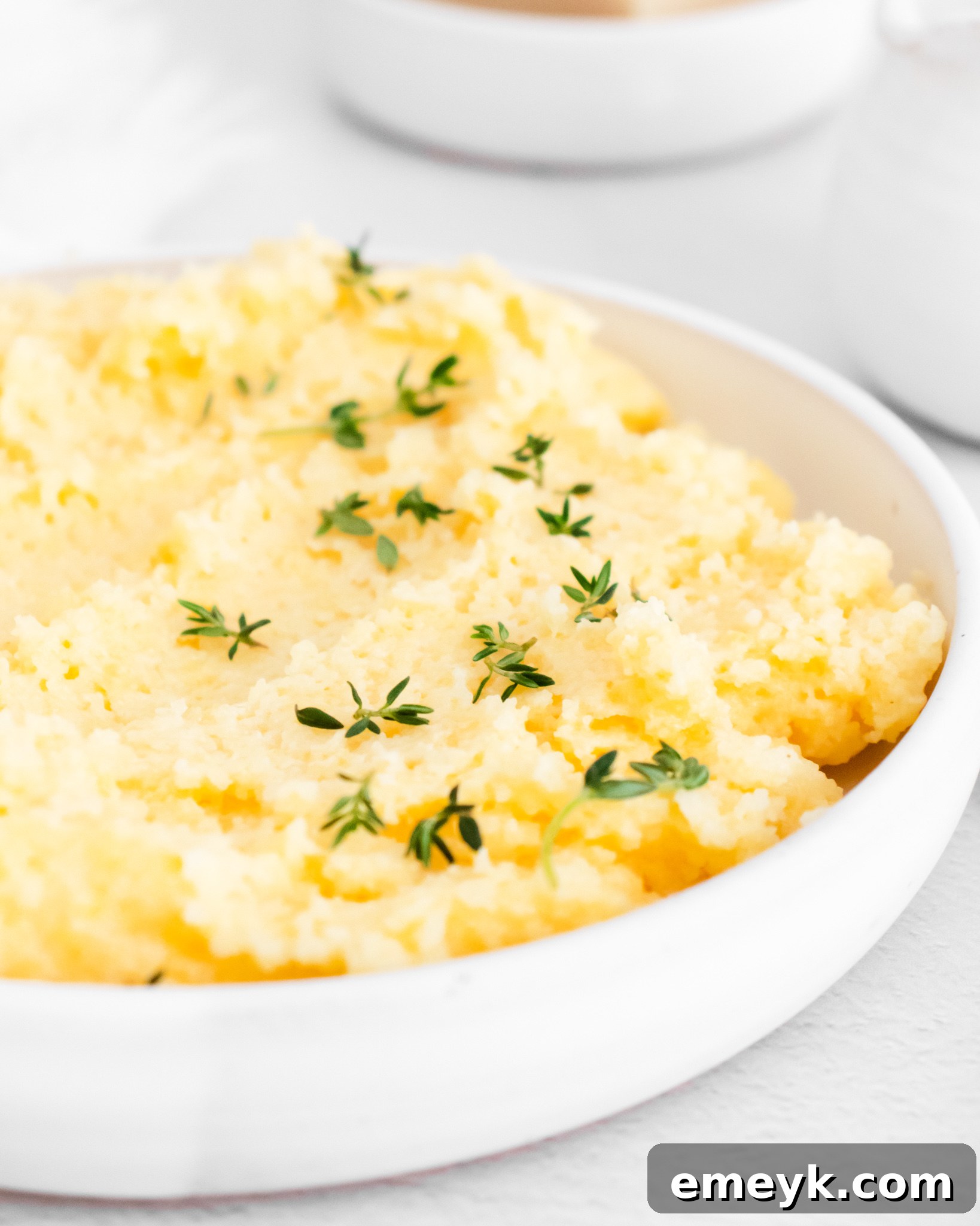 Creamy Polenta Recipe with fresh thyme in a bowl.