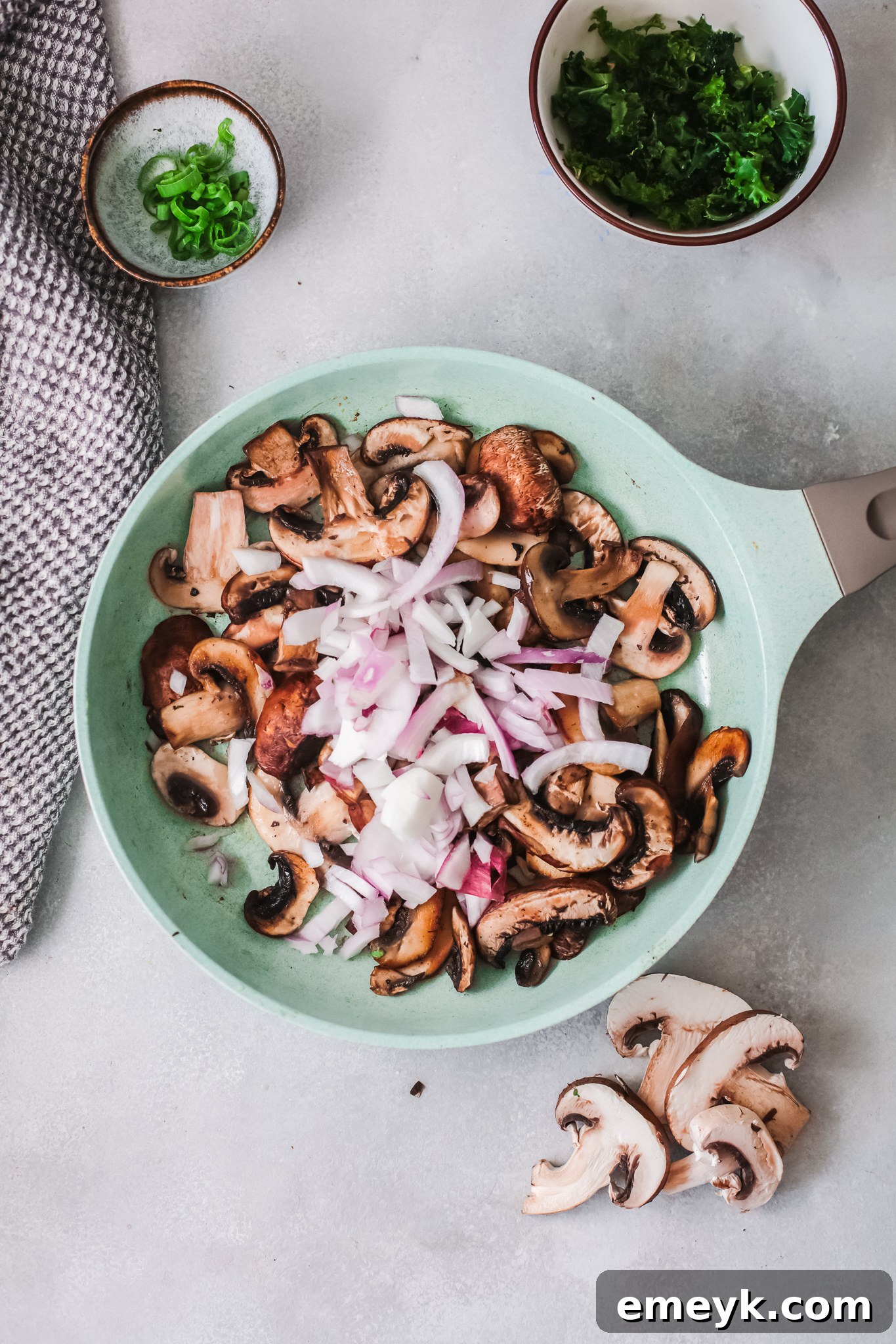 Sautéed mushrooms, red onion, and garlic in a skillet.