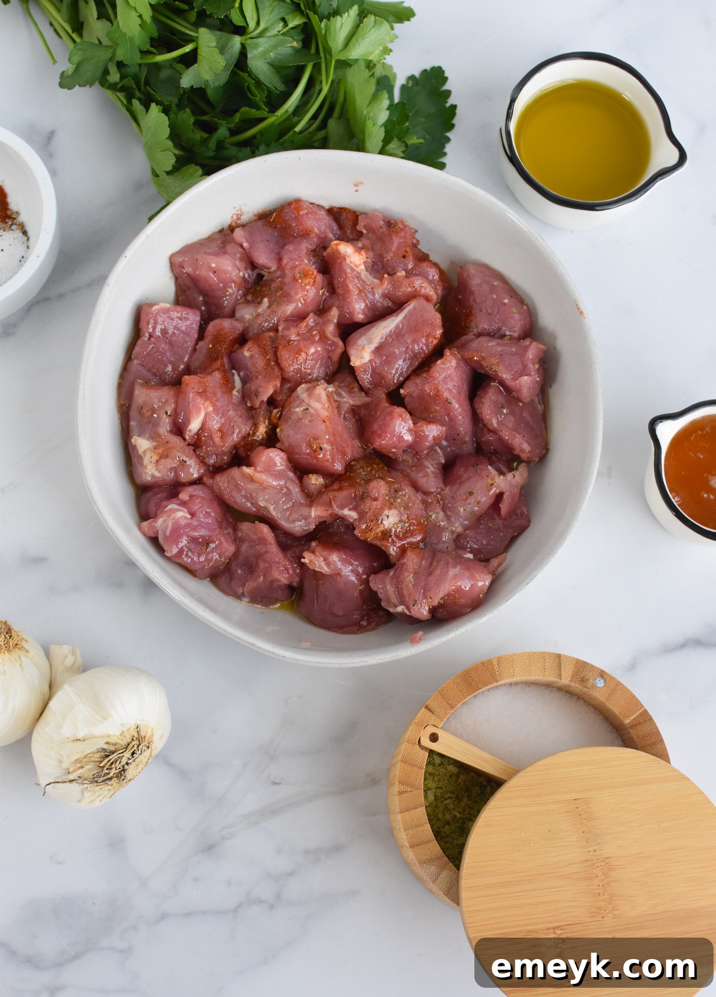 Pork tenderloin cubes seasoned with spices and honey, ready for the cast iron skillet.