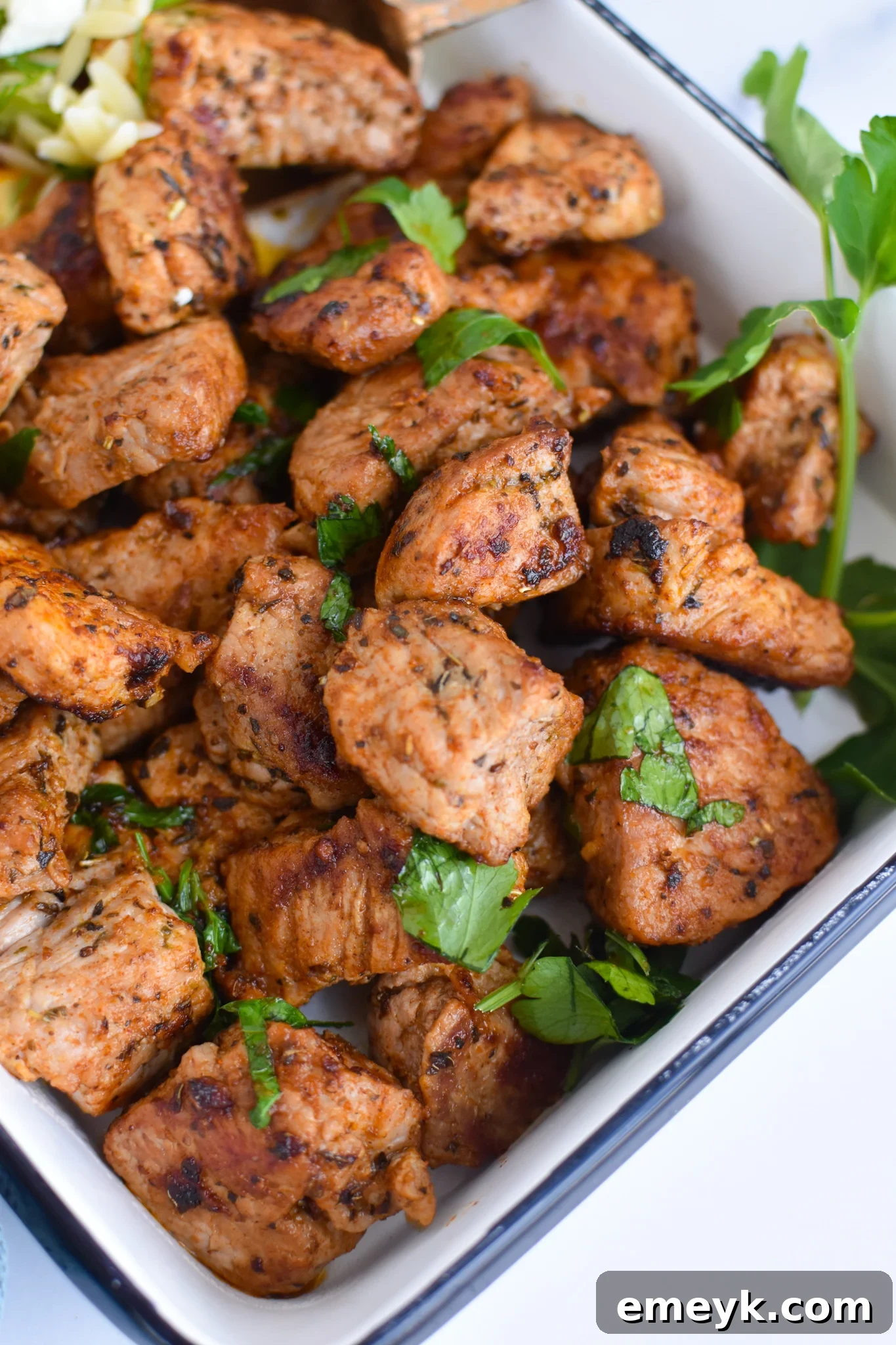 Cooked Cast Iron Pork Tenderloin cubes in a white serving dish.