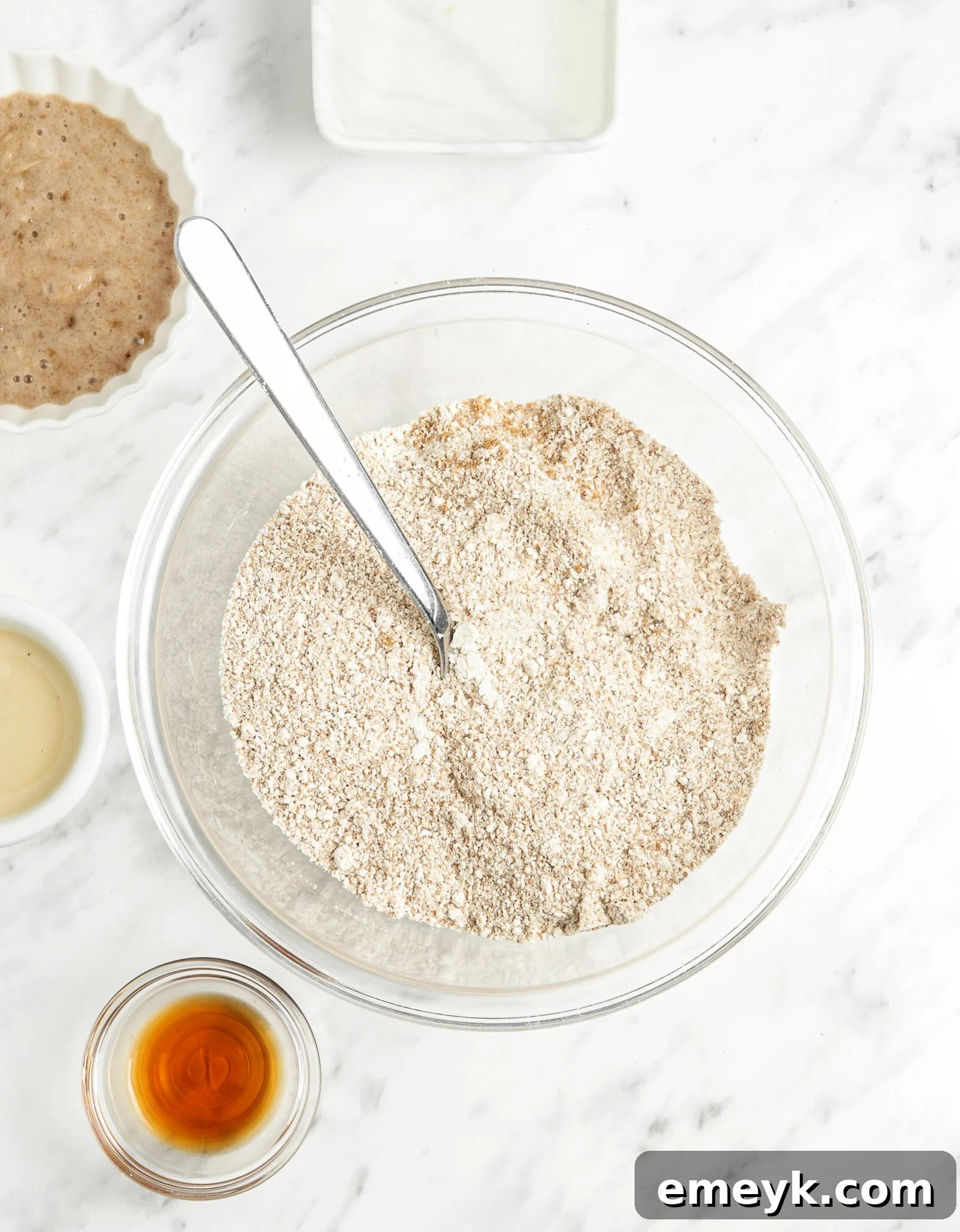 Banana Bliss Oatmeal Cookies 5 Dry ingredients for Homemade Banana Oatmeal Cookies, including oat flour, coconut sugar, and baking powder, mixed in a bowl.