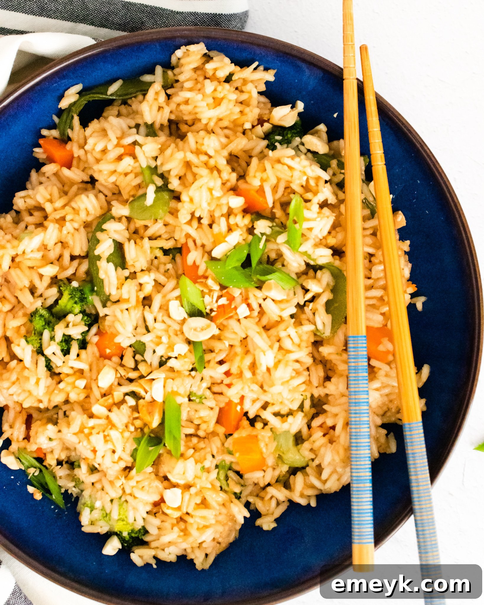 A vibrant blue bowl filled with homemade Instant Pot Fried Rice, garnished with chopped green onions.
