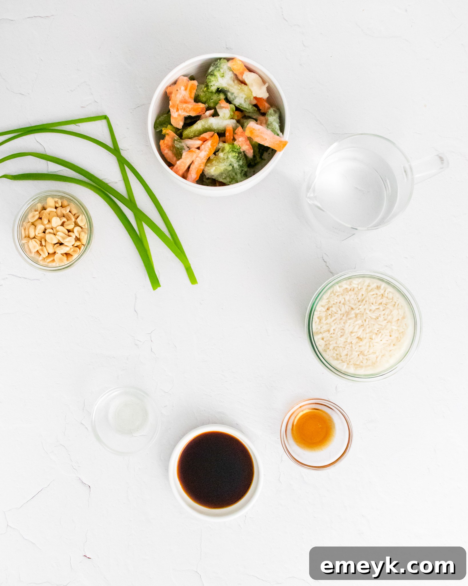Arrangement of Instant Pot Fried Rice ingredients: rice, broth, frozen vegetables, soy sauce, sesame oil, and garnishes.