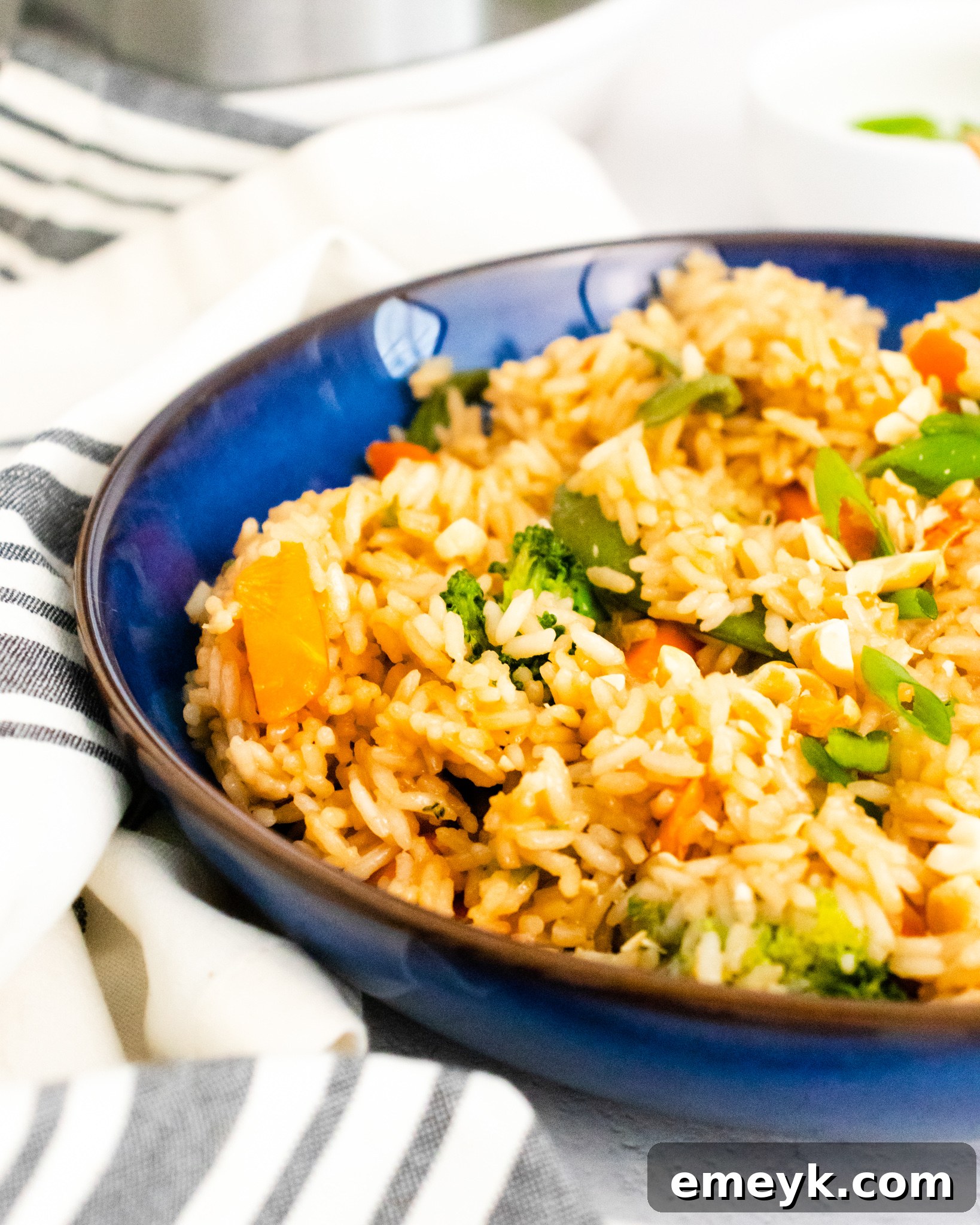 A close-up view of Instant Pot Fried Rice in a blue bowl, ready to be enjoyed with chopsticks.