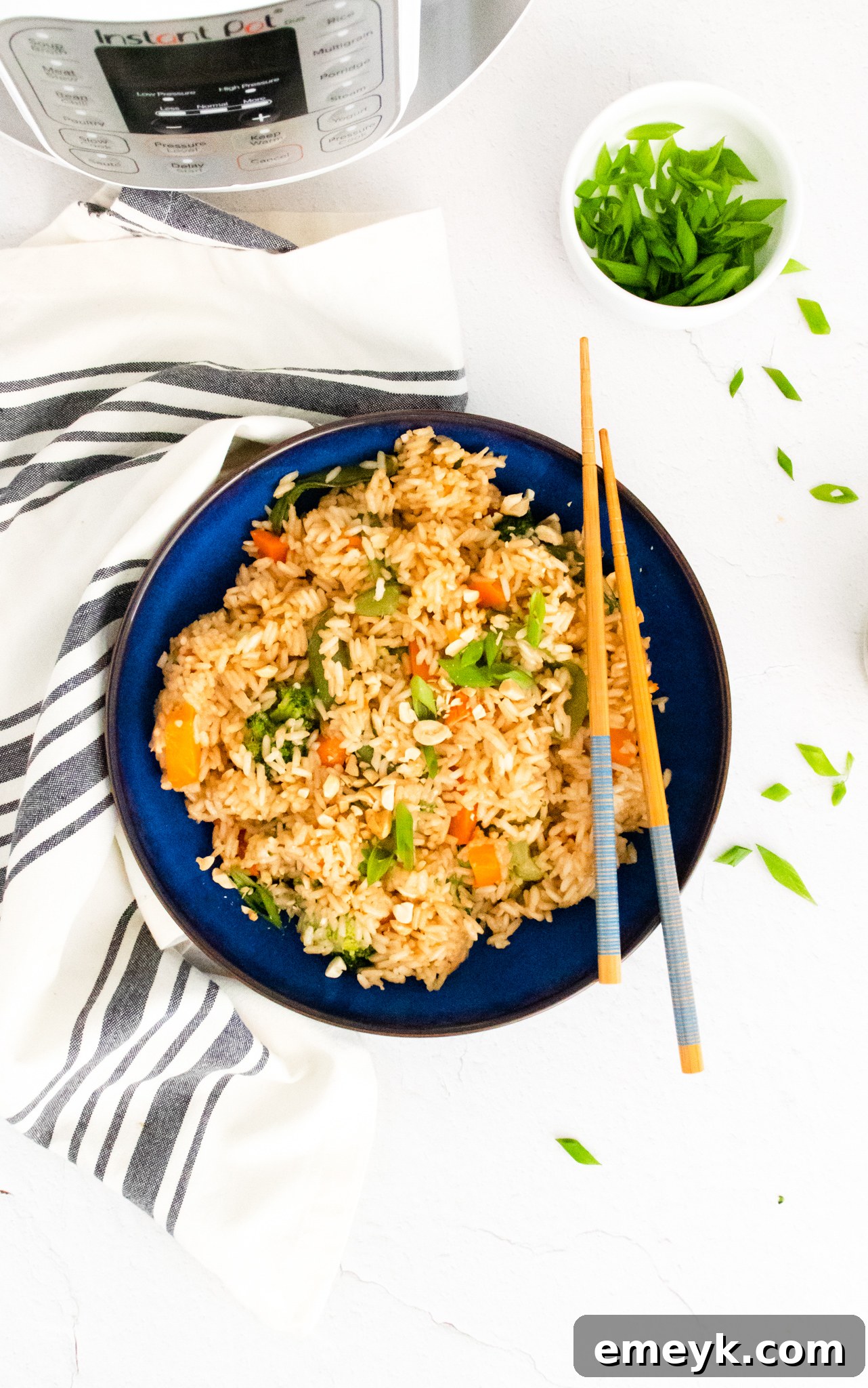 Instant Pot Fried Rice served in a blue bowl with wooden chopsticks resting on the rim.