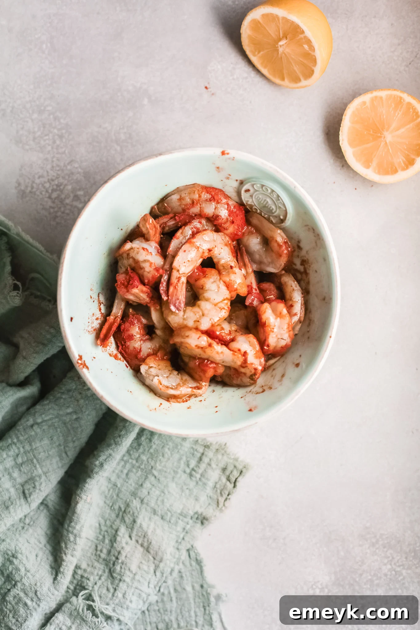 Shrimp seasoned with Cajun spices in a bowl, ready for cooking.