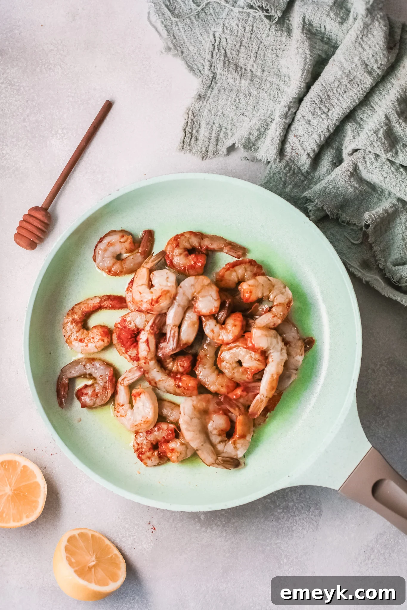 Cajun shrimp cooking in a skillet with butter and honey.