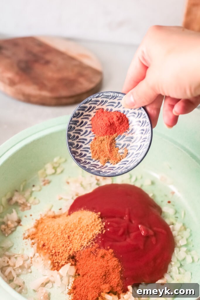 Adding tomato sauce and spices to the Red Lentil Curry base.