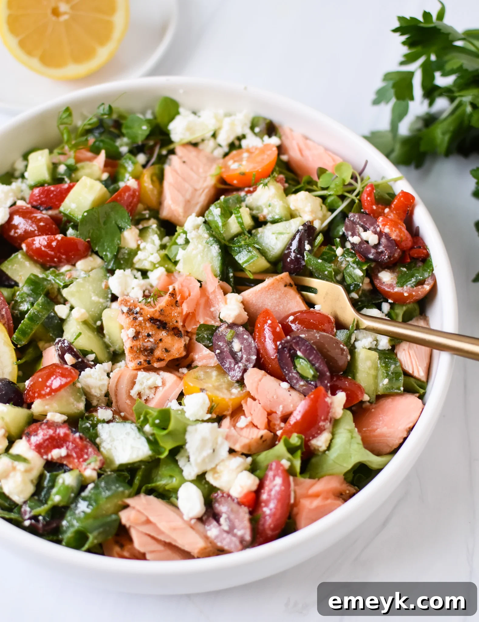 Sun-Drenched Mediterranean Salmon Bowl 2 A vibrant Mediterranean Salmon Bowl featuring flaked salmon, mixed greens, cherry tomatoes, olives, feta, and roasted red peppers, drizzled with lemon dressing.