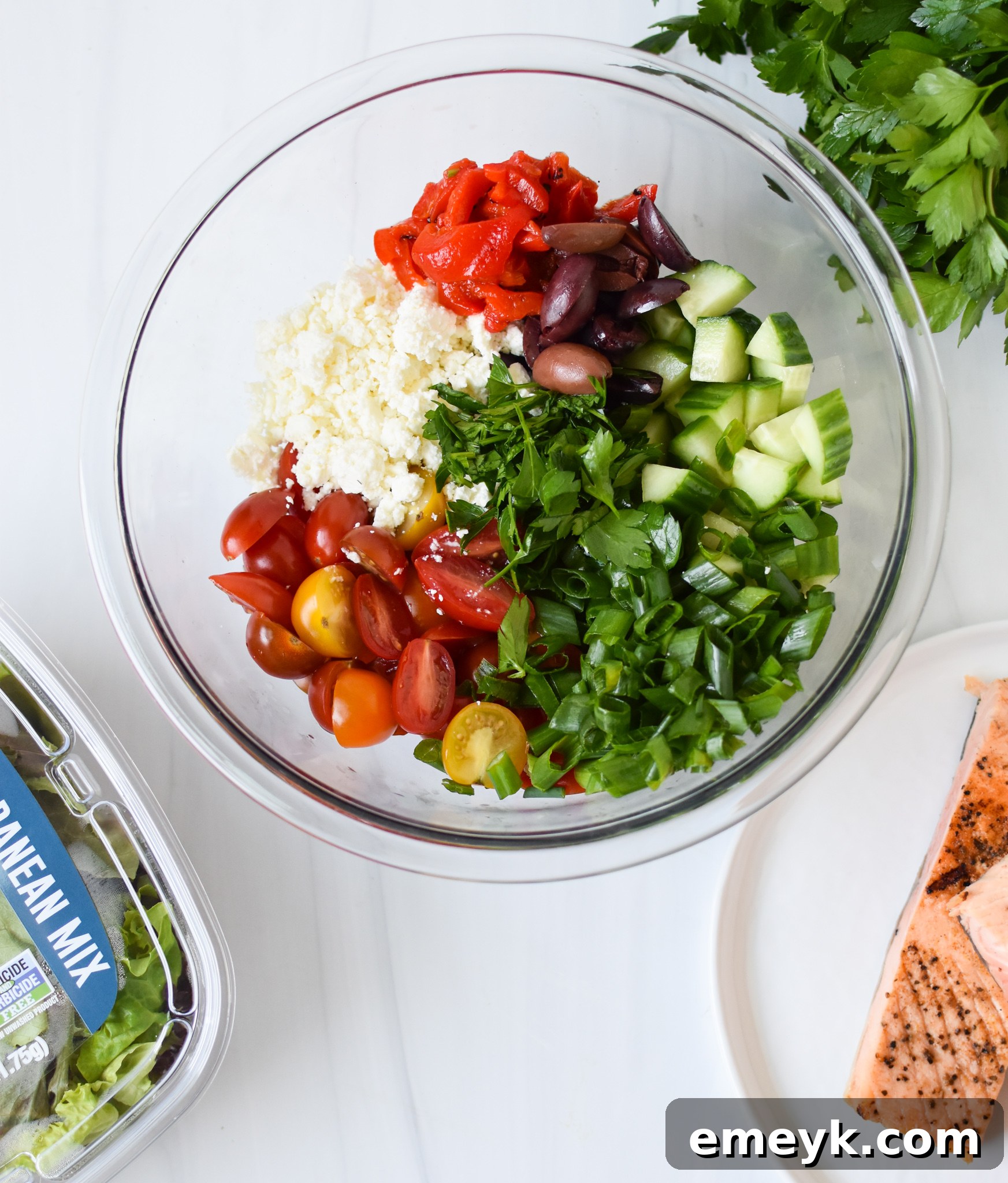 Sun-Drenched Mediterranean Salmon Bowl 4 Mediterranean Salmon Bowl with all ingredients beautifully chopped and arranged in a white bowl, ready to be dressed.