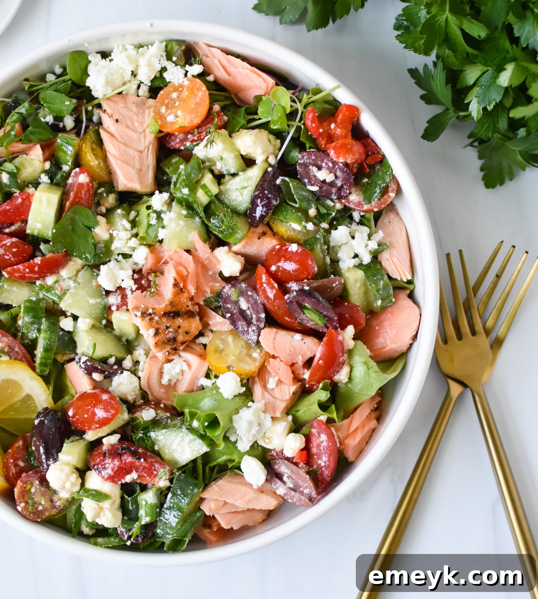 Sun-Drenched Mediterranean Salmon Bowl 7 A close-up shot of a Mediterranean Salmon Bowl with two forks, inviting you to enjoy the fresh and healthy meal.