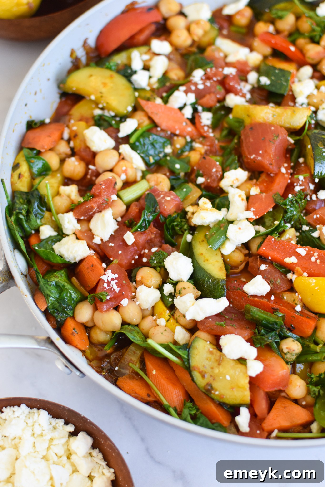 Vibrant Mediterranean Chickpea Skillet 5 Mediterranean Chickpea Skillet simmering in a large cast iron skillet, showcasing the colorful vegetables and chickpeas.