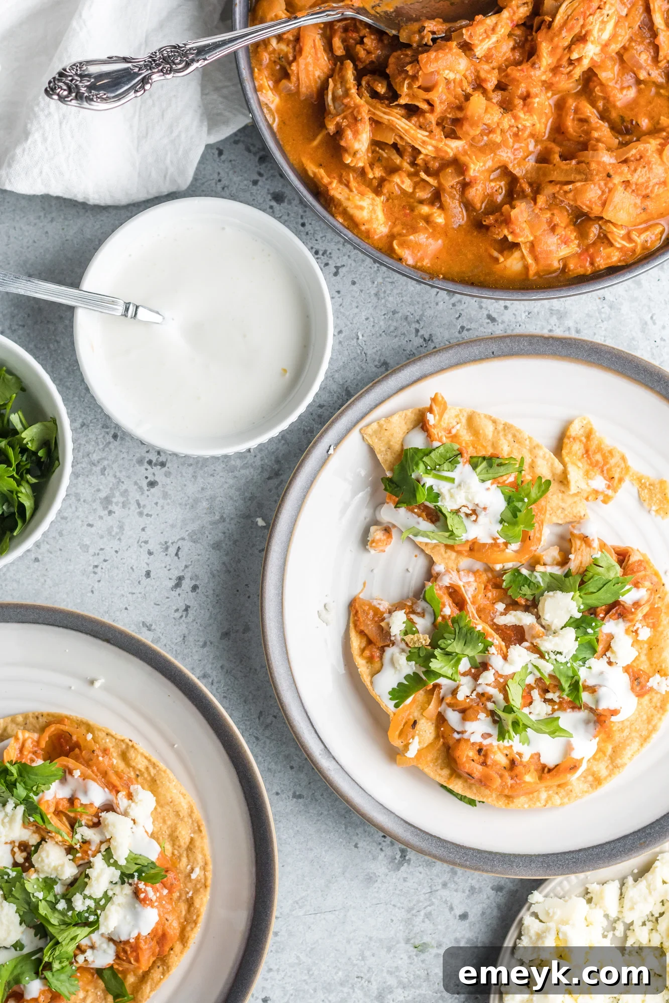 Overhead shot of freshly prepared Chicken Tinga tacos, garnished with cilantro and ready to serve.