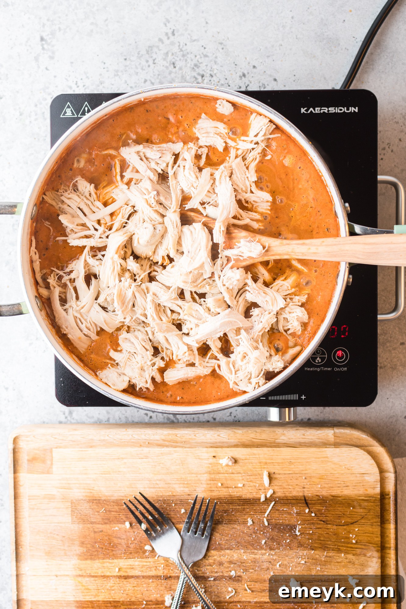 A close-up of tender, shredded chicken mixed into the rich chipotle sauce, forming the core of the Chicken Tinga.