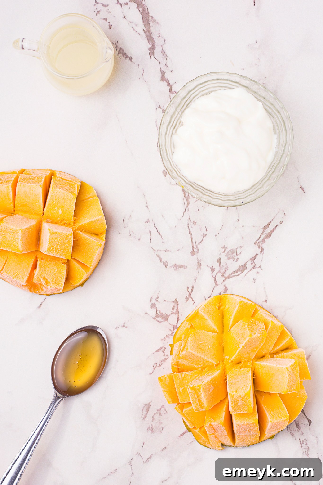 Fresh, ripe mangoes, creamy yogurt, milk, and a small jar of honey laid out as ingredients for Mango Lassi.