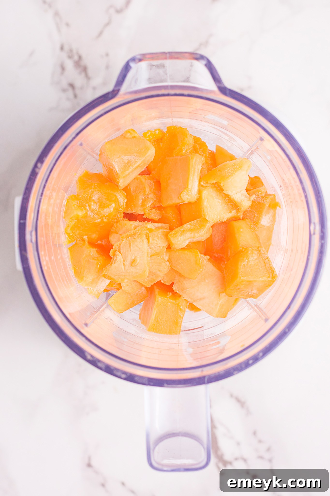 All the ingredients for Mango Lassi being added into a high-speed blender for mixing.