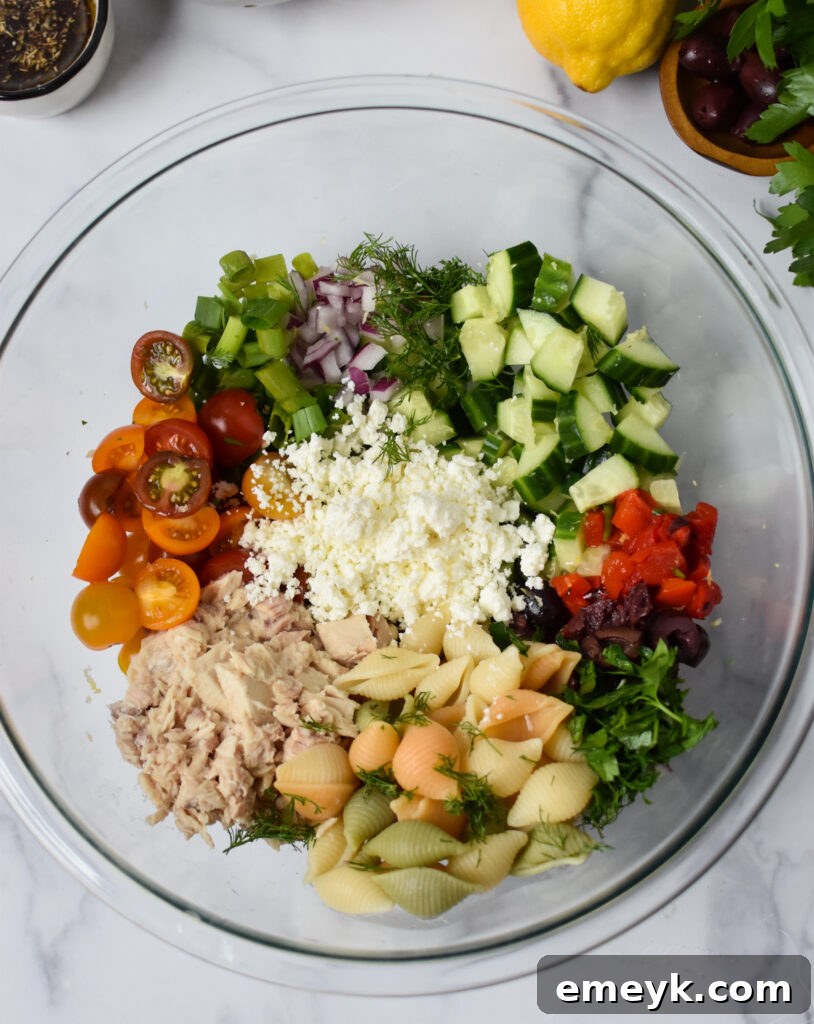 All the mixed ingredients for Mediterranean Tuna Pasta Salad in a large bowl before adding dressing.