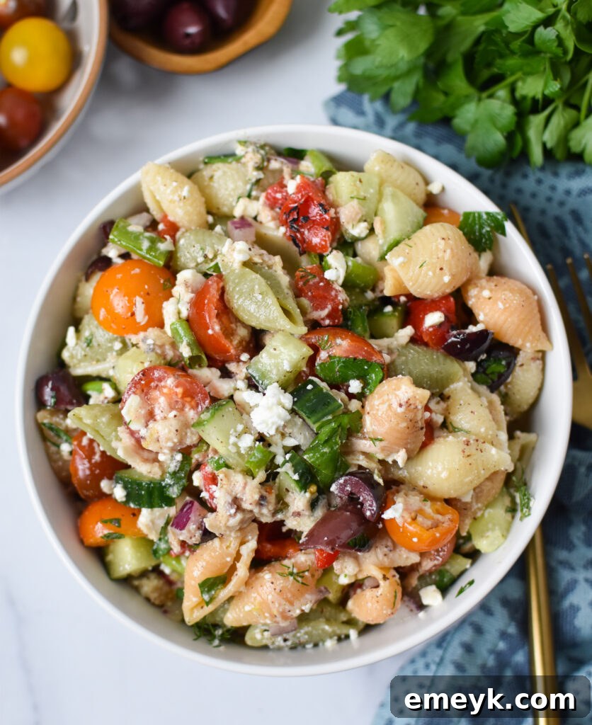 Close-up of Mediterranean Tuna Pasta Salad in a bowl, showing fresh ingredients.