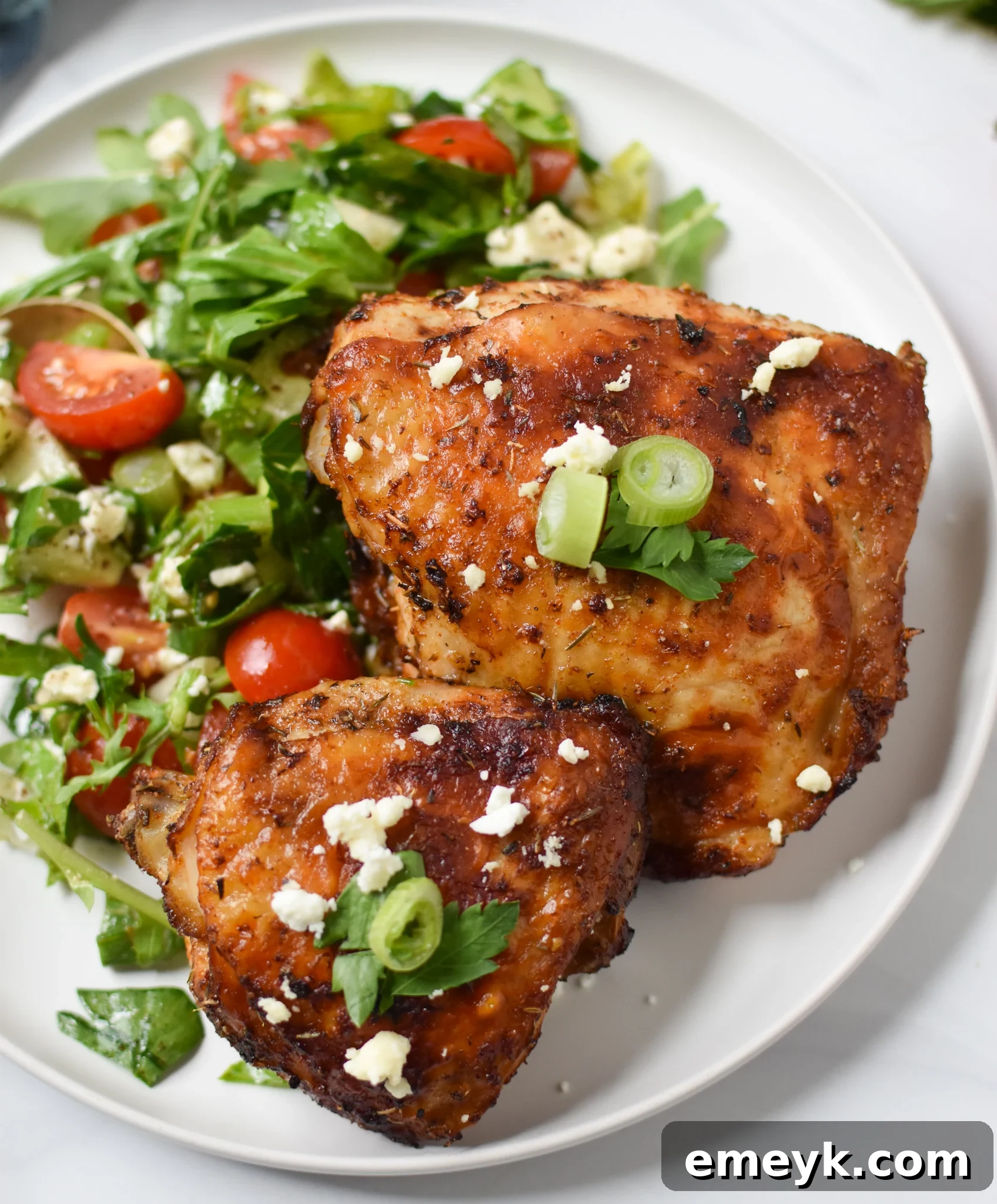 Plate of perfectly cooked Air Fryer Mediterranean Chicken Thighs garnished with fresh herbs.