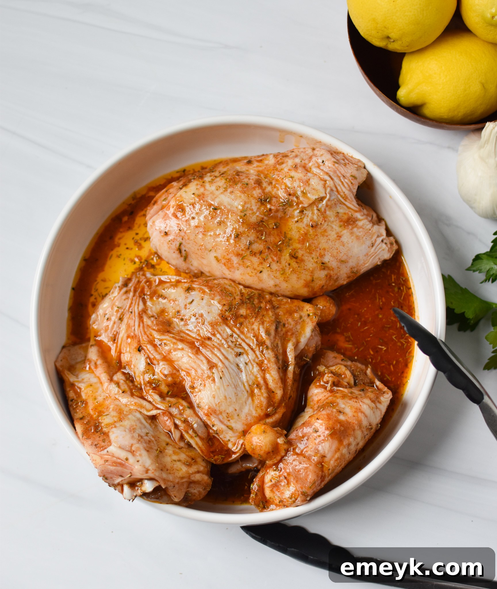 Marinated chicken thighs ready for air frying in a bowl.