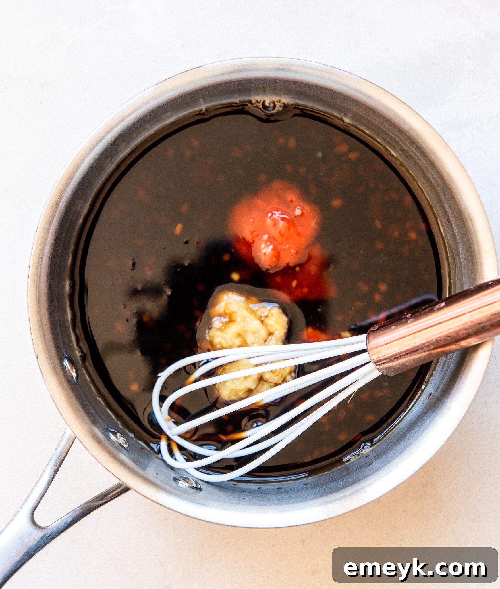 Hawaiian pork rib sauce being poured into the slow cooker over the ribs.