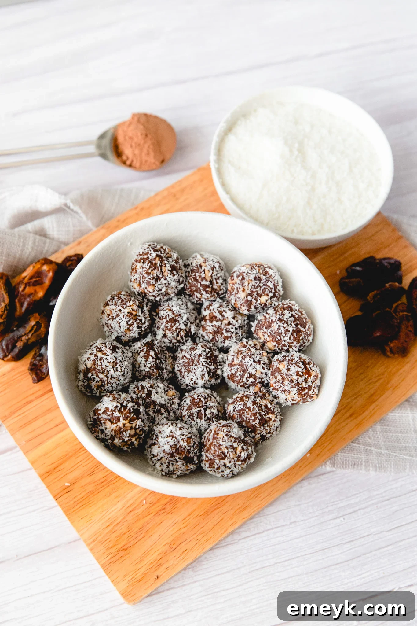 Blended mixture for Easy Date Protein Balls in a bowl, ready for rolling, with coconut for coating.