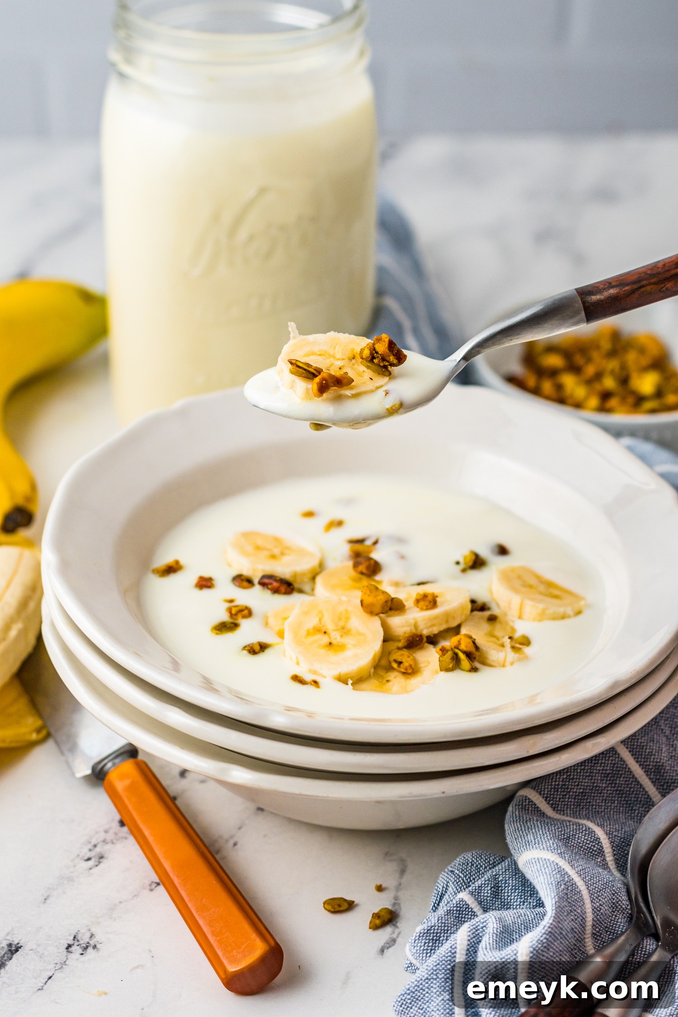Close-up of creamy Instant Pot Yogurt in a bowl, with a spoon taking a scoop, highlighting its smooth texture.