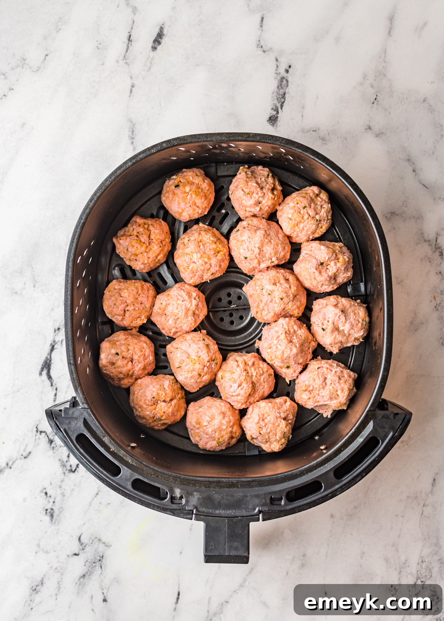 Air Fryer Meatballs cooking inside an air fryer basket, showing their delicious crust.