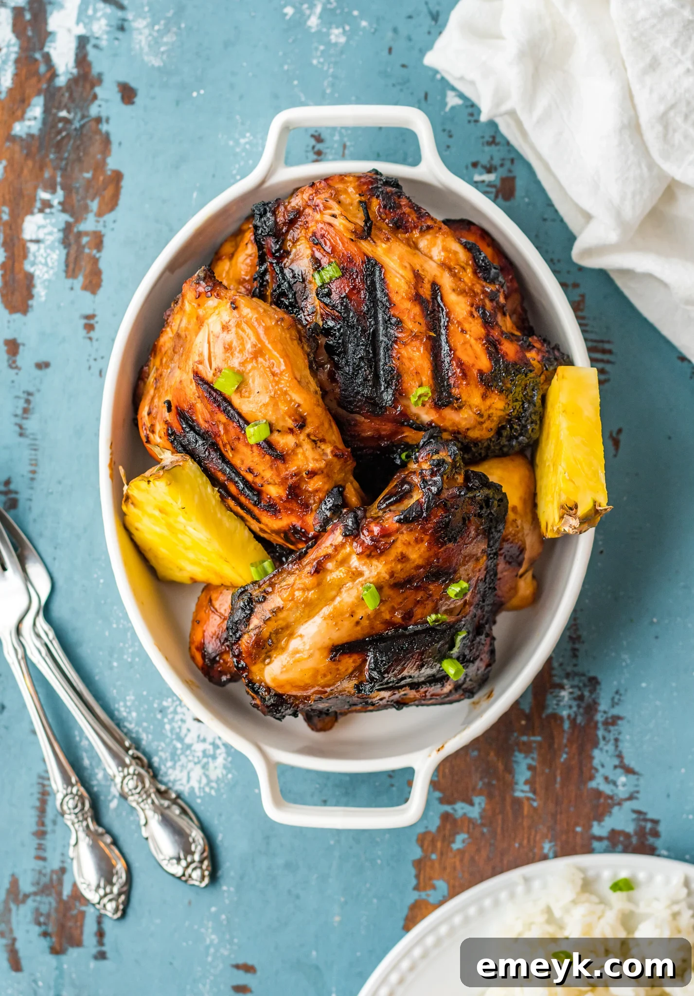 Golden Glazed Huli Huli Chicken 8 Grilled Huli Huli Chicken on a charming blue outdoor table, set for a relaxed meal.