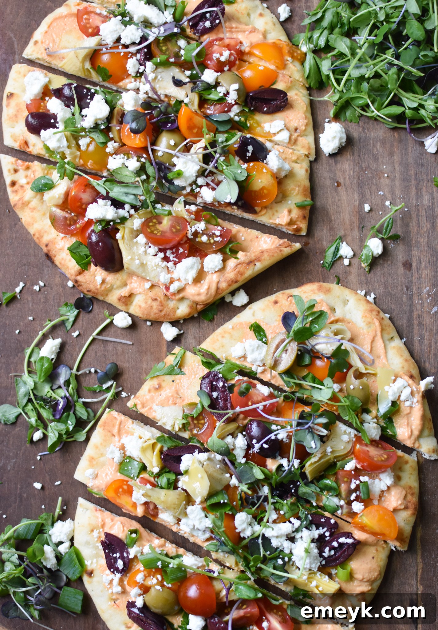 Close-up of Mediterranean Naan Bread Pizza showing fresh greens and feta cheese.