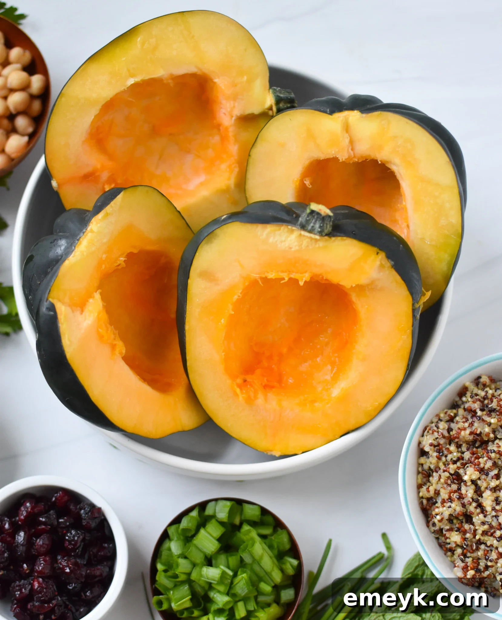 Acorn squash cut in half and placed in a bowl, ready for roasting.