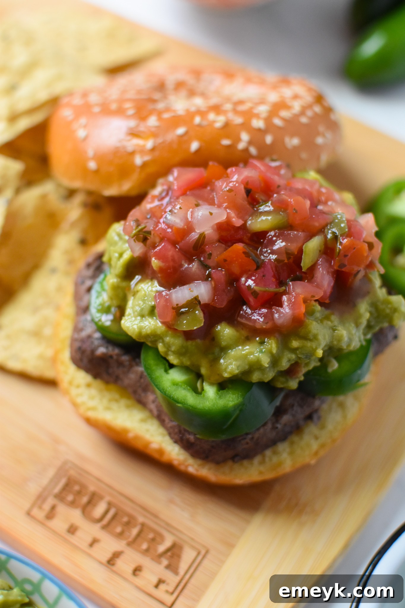 A beautifully assembled Tex Mex Burger with vibrant pico de gallo overflowing, ready to be enjoyed.