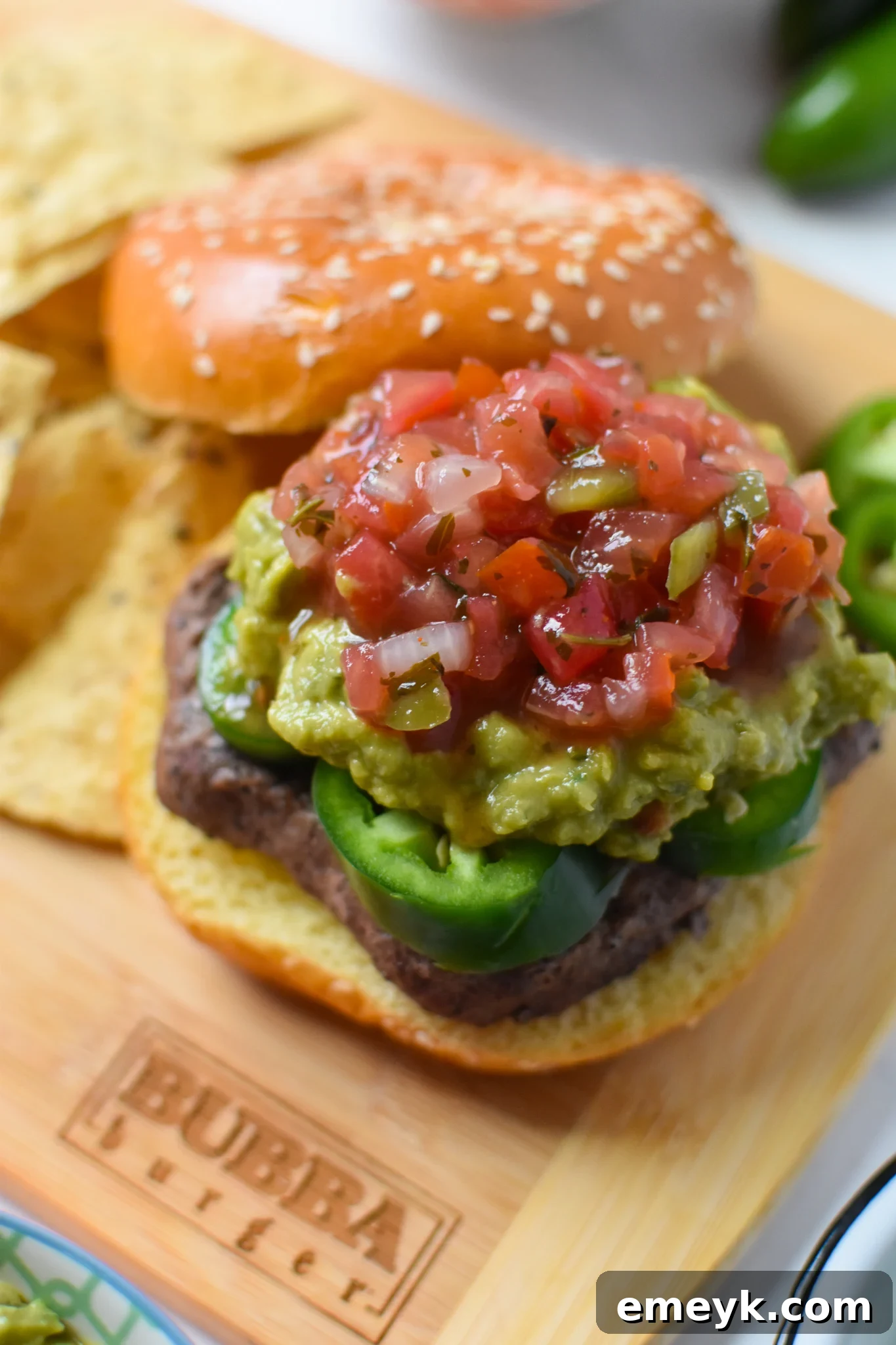 A Tex Mex Burger topped generously with creamy guacamole, ready to be served.