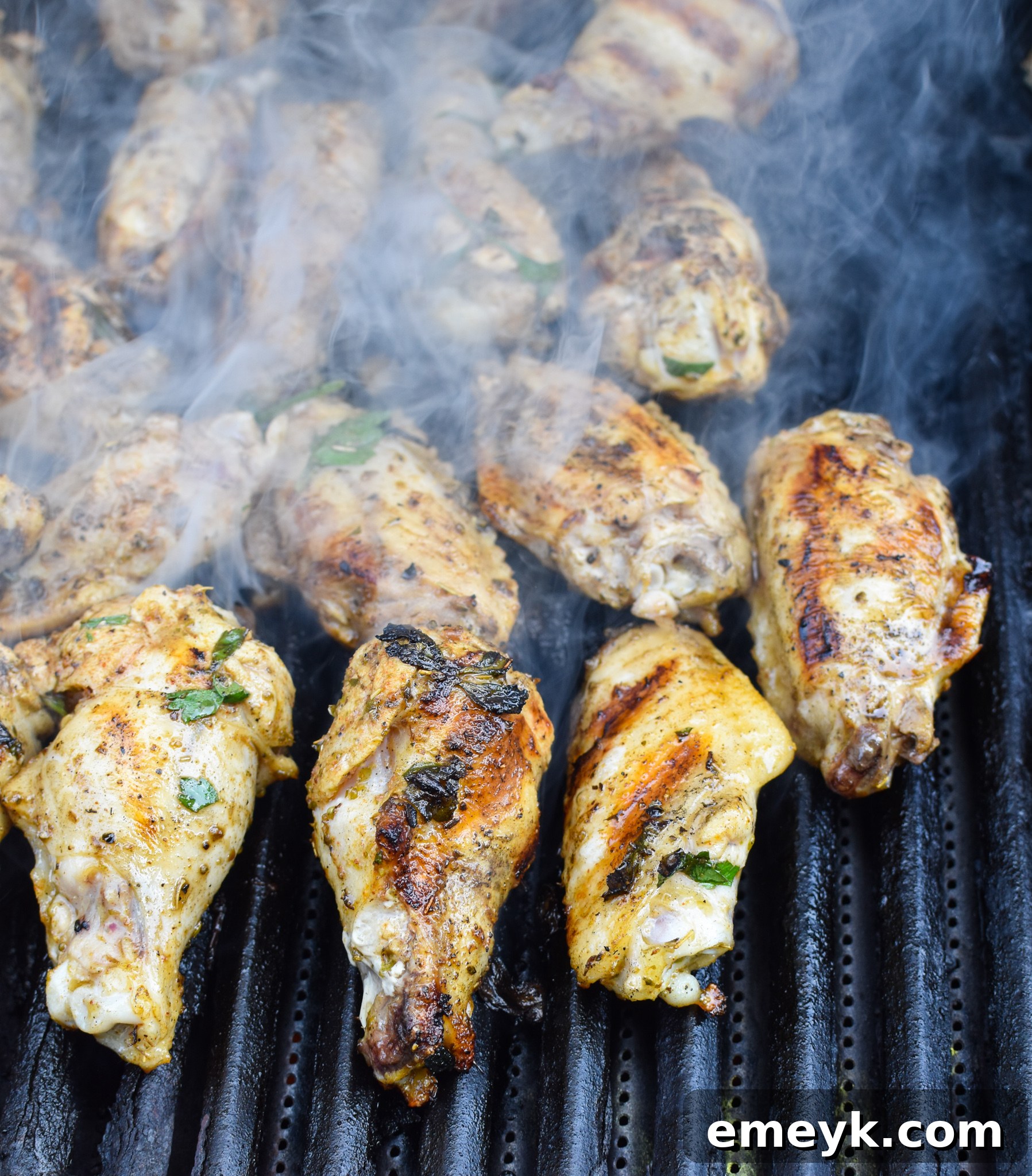 Mediterranean Chicken Wings grilling on an outdoor gas grill.