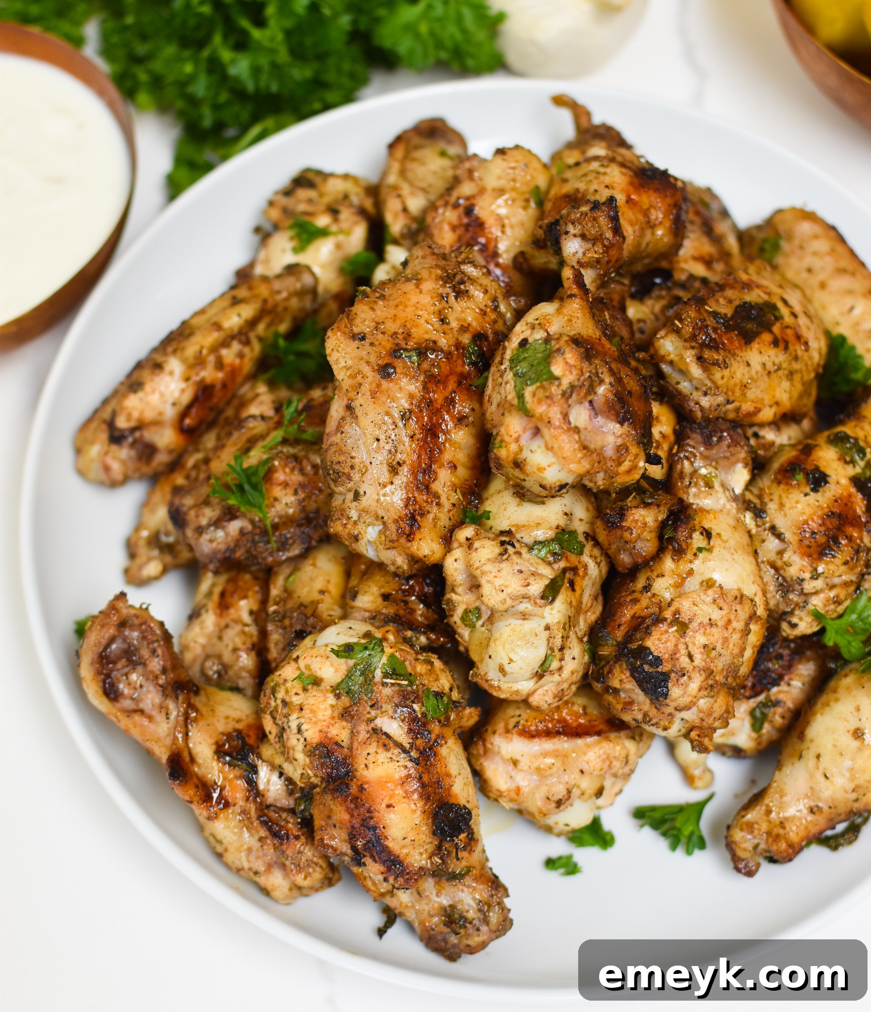 Platter of freshly Grilled Mediterranean Chicken Wings, garnished with chopped parsley.