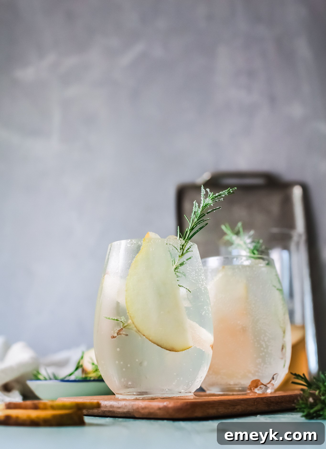 White Sangria Recipe pitcher with rosemary and pear slices.