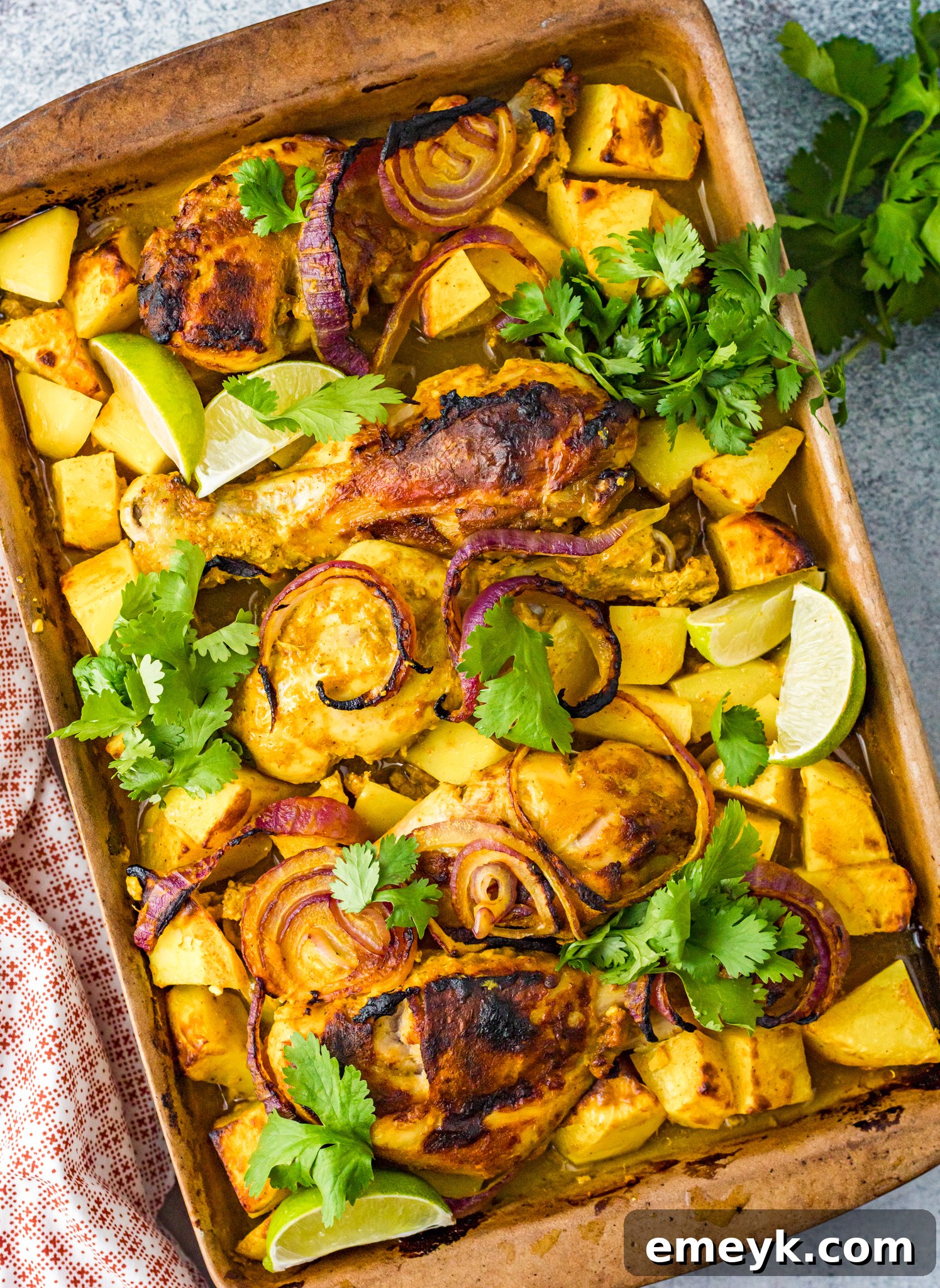 Crispy Air Fryer Tandoori Chicken Legs 2 Golden brown Air Fryer Tandoori Chicken Legs garnished with fresh cilantro, served on a rustic baking sheet.