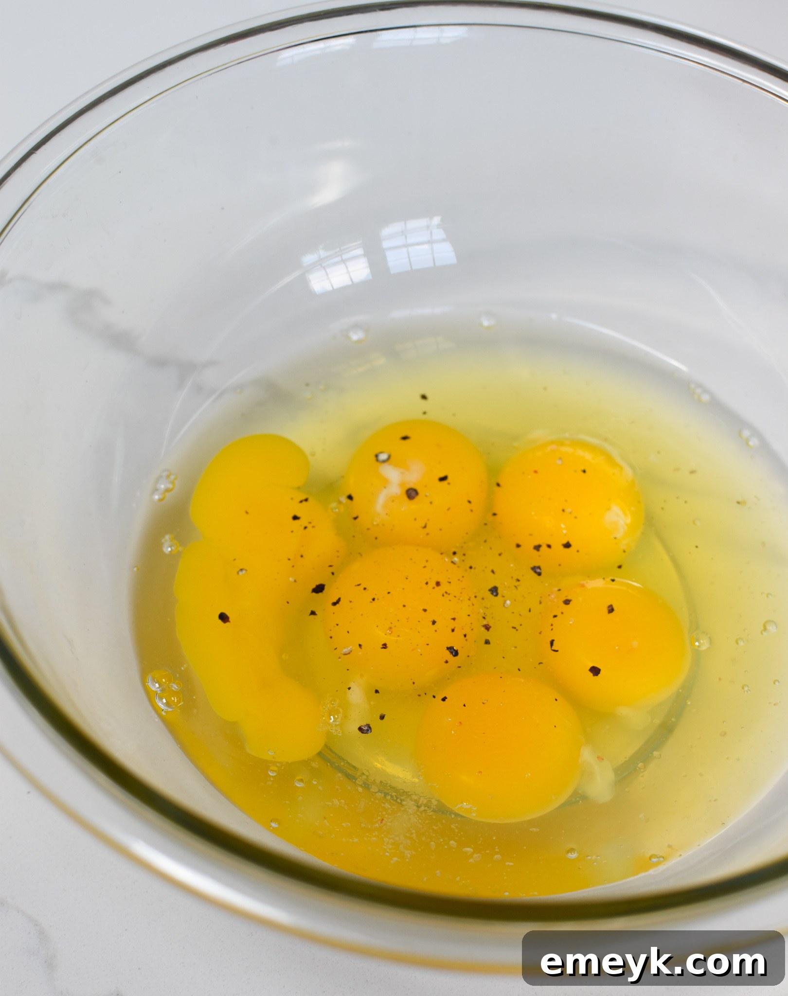 Whisked eggs in a bowl, the first step in making the chaffles recipe.