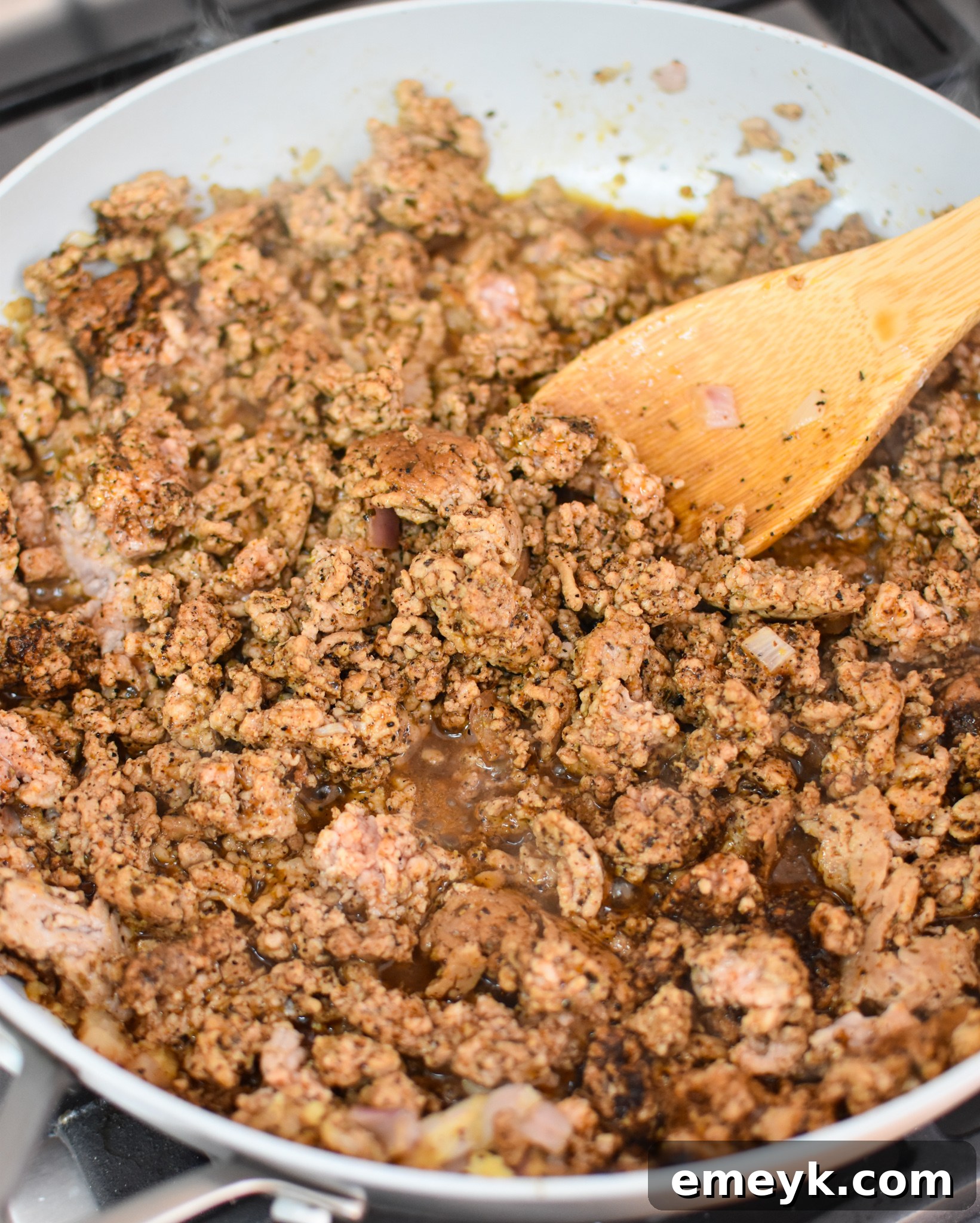 Ground pork cooking in a skillet with Southwestern spices and salsa, forming the taquito filling.