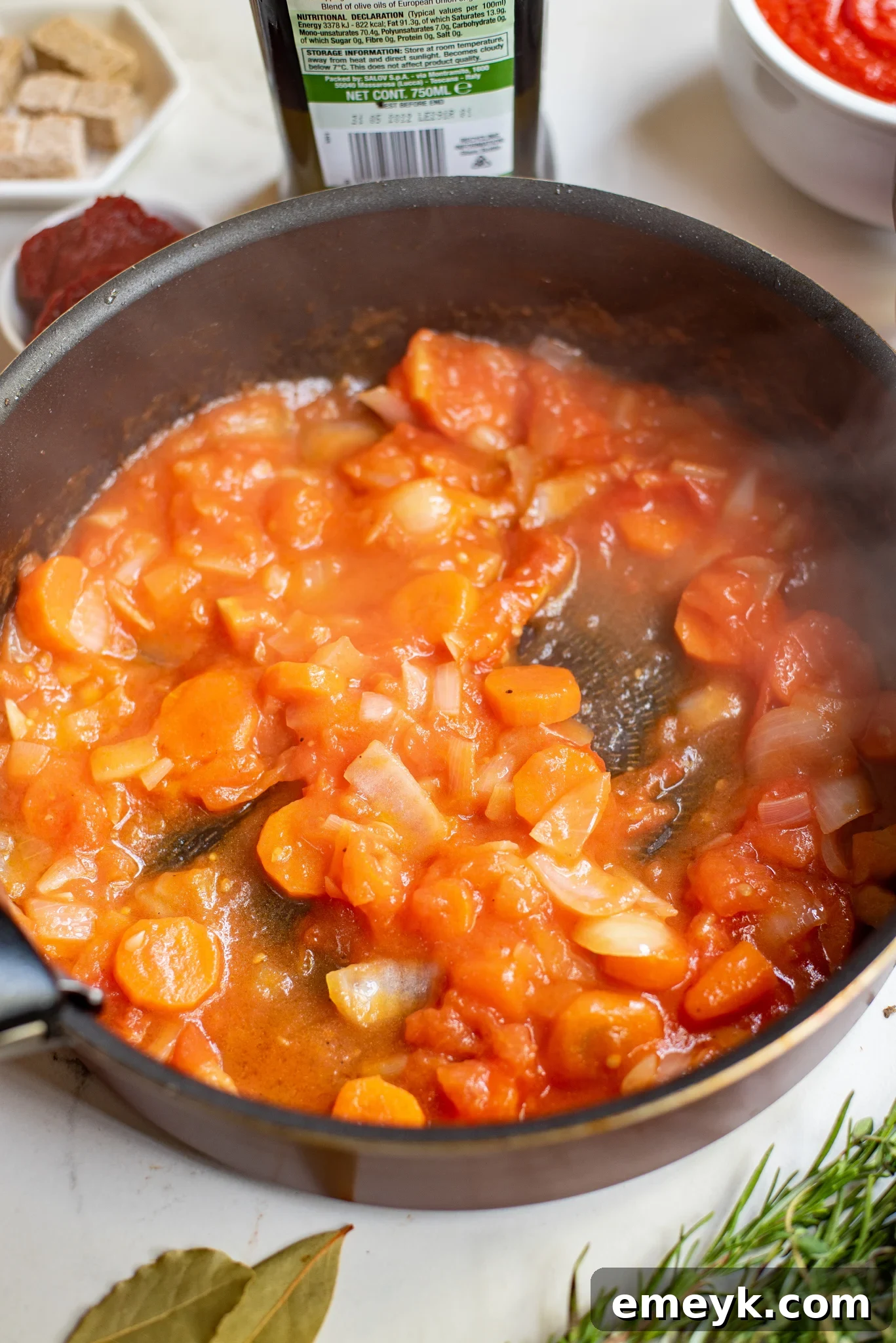 Braised Lamb Shanks Recipe sauce base cooking in a skillet with vegetables.