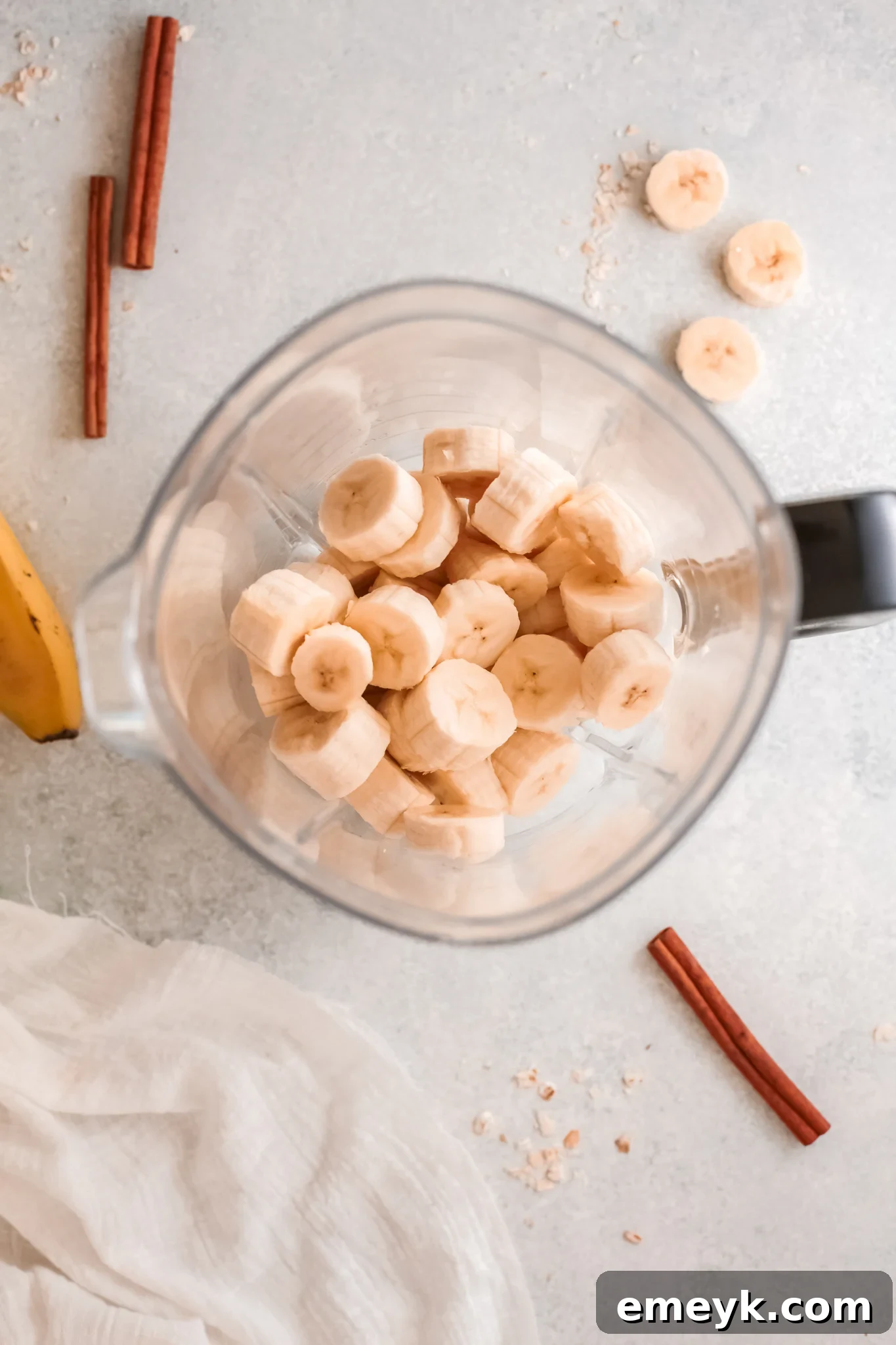 Peeled bananas being added to a blender, a key step for the Oat Smoothie Recipe.
