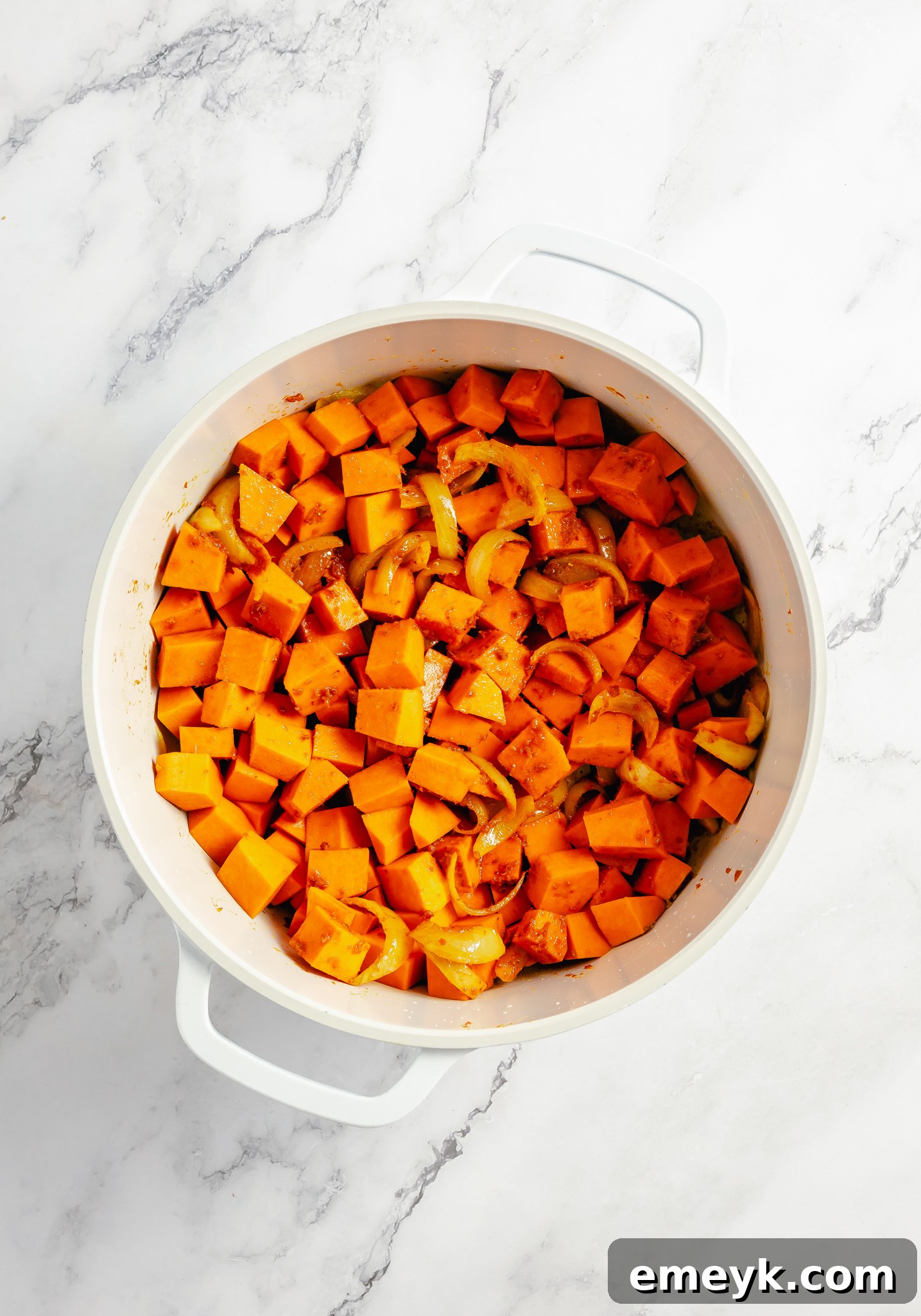 Velvety Pumpkin Curry 5 Diced fresh pumpkin coated in spices and sautéing in a pot for pumpkin curry.