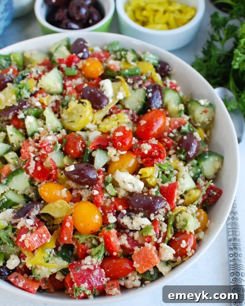 Vibrant Greek Quinoa Salad in a white serving bowl, showcasing its fresh ingredients.