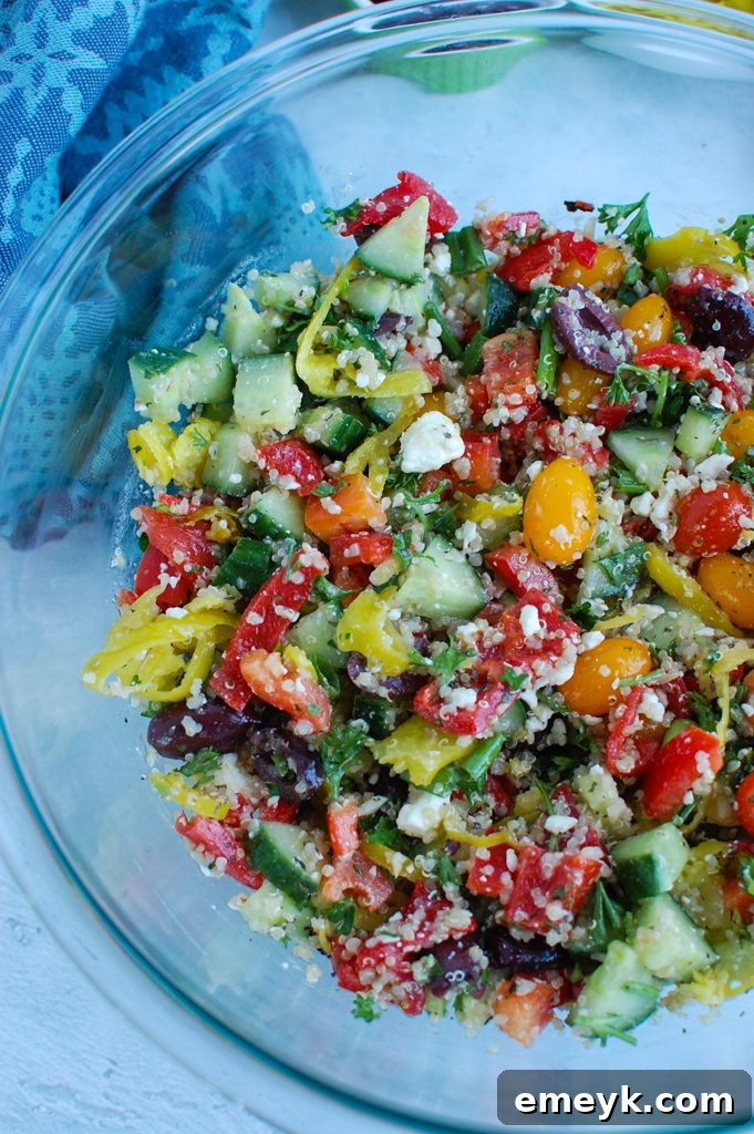 Close-up of Greek Quinoa Salad in a clear bowl, highlighting the colorful ingredients.