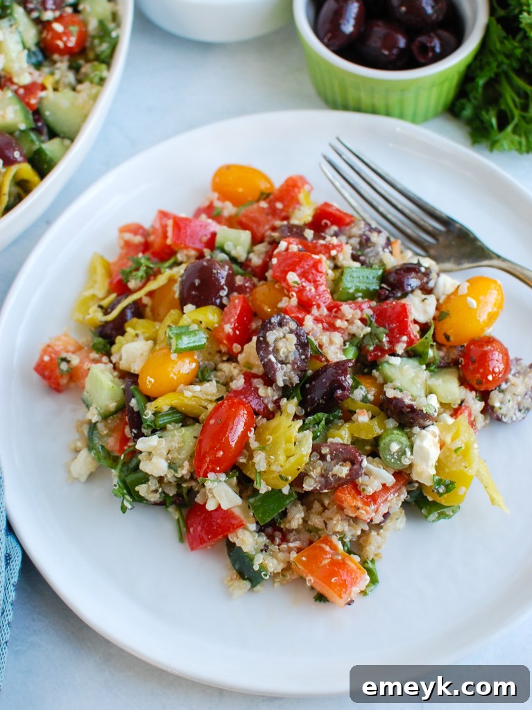 A serving of Greek Quinoa Salad with a fork, ready to be eaten.